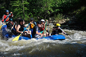 Several people in a raft on whitewater. 